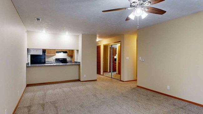 Nuestro plano de planta Imperial ofrece una sala de estar y un comedor abiertos, complementados con una barra de cocina. - Pine Lake Heights Apartments