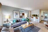 Located in San Jose, CA, this one-bedroom, one-bathroom residence offers a thoughtfully designed single-floor layout that maximizes every square foot. The open-concept living and dining area is anchored by soft, neutral-toned carpet and cool sage-green accent walls, creating a calm and welcoming atmosphere. Large windows allow natural light to pour in, offering views of the surrounding greenery, while a sliding glass door provides direct outdoor access. A pass-through counter with bar seating connects the living area to the galley-style kitchen, which features white cabinetry, stainless steel appliances including a refrigerator and range, wood-look flooring, and ample counter space — ideal for everyday cooking. The bedroom is a quiet retreat, finished with plush carpet, neutral walls, and a window framing colorful outdoor views. A dedicated closet provides convenient storage. The bathroom is clean and functional, featuring a wide vanity with white cabinetry, a large mirror with overhead lighting, and tile-look flooring. Together, the rooms form a cohesive, efficiently organized living space with a modern yet comfortable character, well-suited for those seeking a streamlined lifestyle in the heart of San Jose.