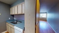 Located at 3185 Contra Loma Blvd in Antioch, California, this single-floor unit offers a functional and comfortable layout designed for everyday living. The open living area is a standout feature, showcasing warm hardwood-style flooring that extends throughout the space, creating a cohesive and inviting atmosphere. Natural light filters in through large windows fitted with vertical blinds, brightening the living and bedroom areas alike.

The galley-style kitchen is efficiently designed with light wood cabinetry offering ample storage above and below the counters, blue-gray laminate countertops, a double basin sink, a dishwasher, a stove, and a full-size refrigerator. A microwave is also included. The kitchen opens conveniently toward the living area via a pass-through layout, enhancing the sense of connectivity within the unit.

The bedrooms are generously proportioned with neutral gray walls and large windows that allow for plenty of natural light. The unit includes two bathrooms: one features a tiled tub-shower combination with a safety grab bar, while the second offers a standalone shower stall paired with a light wood vanity, a blue-gray countertop, an integrated sink, and a large mirror. Both bathrooms continue the hardwood-style flooring found throughout the rest of the unit.