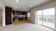 This single-floor unit offers a thoughtfully designed layout that balances functionality with modern style. The open-concept living and kitchen area serves as the heart of the space, where rich dark-espresso cabinetry contrasts elegantly with granite countertops and a full suite of stainless steel appliances, including a side-by-side refrigerator with ice and water dispenser, an electric range, built-in microwave, and dishwasher. Light wood-look flooring flows through the kitchen and transitions seamlessly to plush carpeting in the living area. A sliding glass door floods the space with natural light and opens to a private balcony, offering views of the surrounding exterior. The bedrooms are carpeted and finished with neutral tones, providing a calm and versatile canvas. Each room benefits from natural light through well-placed windows. A walk-in closet with wire shelving systems offers generous and organized storage. The full bathroom is outfitted with a dual-sink granite vanity, dark cabinetry, wood-look flooring, and a tiled combination tub and shower. Recessed lighting throughout enhances the clean, modern ambiance of the entire unit.