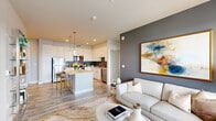 Located at 520 Sahwatch St in Colorado Springs, CO, this well-appointed 2-bedroom, 2-bathroom residence offers a thoughtfully designed open-concept layout finished with contemporary details throughout. Light wood-style flooring flows seamlessly through the main living areas, anchoring a bright and cohesive aesthetic.

The kitchen is a standout feature, outfitted with white shaker cabinetry, stainless steel appliances, a textured tile backsplash, quartz countertops, and a central island with bar seating illuminated by pendant lighting. It opens directly into the living room, which is accented by a bold feature wall and large windows that invite natural light and offer views of the surrounding cityscape and mountains.

Both bedrooms are carpeted and include ceiling fans, generous windows with outdoor views, and access to dedicated closets. The primary bedroom provides a comfortable, well-proportioned retreat. The bathrooms are cleanly finished, with one featuring a soaking tub surrounded by classic white subway tile. A dedicated in-unit laundry closet with a stacked washer and dryer adds everyday convenience.

The second bedroom offers flexibility as a home office or guest room, with dual windows framing vibrant outdoor scenery. The overall ambiance is modern and refined, combining neutral tones with curated design elements throughout.
