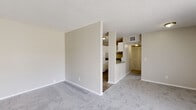Located at 7147 Old Kings Rd S in Jacksonville, FL, this single-floor unit offers a well-organized layout designed for comfortable everyday living. The spacious living area is finished with plush gray carpeting and neutral-toned walls, creating a clean and versatile backdrop. A large sliding glass door floods the space with natural light and opens to a private patio overlooking lush greenery, seamlessly connecting the interior to the outdoors.

The kitchen is efficiently designed with white cabinetry, light countertops, a full suite of white appliances including a refrigerator and electric range, and durable wood-look vinyl flooring. A pass-through opening connects the kitchen to the living area, promoting an open and airy feel throughout.

The bedrooms are generously sized, each featuring soft carpeting, neutral walls, and windows with outdoor views that bring in ample natural light. Closet space is well-represented, with at least one bedroom offering a dedicated closet fitted with louvered bifold doors, a hanging rod, and a shelf.

The bathroom is cleanly appointed with a white vanity, medicine cabinet mirror, lighted vanity bar, and wood-look vinyl flooring, providing a practical and tidy space. Overall, the unit presents a functional, move-in-ready environment in a convenient Jacksonville location.