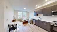 Located at 3918 N Wall St, Unit 410 in Spokane, WA, this well-appointed one-bedroom, one-bathroom unit offers a thoughtfully designed open-concept layout that efficiently combines the kitchen, dining, and living areas into a cohesive, light-filled space. Light-toned hardwood-style flooring runs throughout, lending warmth and visual continuity across every room.

The kitchen is a standout feature, showcasing dark wood cabinetry with sleek hardware, crisp white countertops, and a full suite of stainless steel appliances including a refrigerator, electric range, built-in microwave, and dishwasher. The adjacent living area is anchored by large windows that frame neighborhood views and fill the space with natural light, creating an inviting and airy atmosphere.

The bedroom is a comfortable retreat with generous windows offering additional outdoor views, light wood-style flooring, and a ceiling fan for year-round comfort. The bathroom features a clean, modern aesthetic with a floating wood vanity, white countertop, round mirror, matte black fixtures, and wood-toned tile flooring that ties the space together elegantly.

Neutral tones throughout and recessed lighting contribute to the unit's contemporary, move-in-ready appeal, making this Spokane residence a practical and stylish place to call home.
