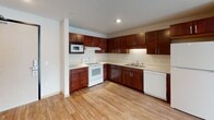 Located at 8412 22nd Ave S in Bloomington, Minnesota, this single-floor unit offers a practical and well-designed layout suited for comfortable everyday living. The open-concept living area is finished with light hardwood-style flooring that extends throughout the main spaces, creating a cohesive and bright atmosphere. Large windows allow natural light to fill the living area, enhancing the clean, neutral palette of the interior.

The kitchen is a standout feature, offering rich dark cherry cabinetry with modern hardware, light countertops, and a full suite of white appliances including a range, built-in microwave, dishwasher, and refrigerator. A double-basin sink and ample upper and lower cabinet storage make this kitchen both functional and attractive. The kitchen flows openly into the living space, ideal for everyday use.

The unit includes two carpeted bedrooms, each providing a quiet retreat. One bedroom features a window with blinds for natural light and privacy, while the other includes a built-in storage wardrobe.

Two full bathrooms serve the unit, both featuring tile flooring, a tub/shower combination, and dark wood vanity cabinetry with white countertops and a mirror. The clean, minimal design ensures a bright and functional experience throughout.