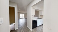 Located on Alan Drive in Weatogue, Connecticut, this two-bedroom, two-bathroom two-story home offers a well-organized layout across two levels. The lower level houses a combined kitchen and living area, a utility room, and a staircase connecting to the upper floor. The kitchen features white cabinetry, a stainless sink, a black dishwasher, and stainless steel refrigerator, with wood-look flooring that extends seamlessly into the spacious living area. A sliding glass door floods the living room with natural light and provides outdoor access. The upper level contains both bedrooms, two full bathrooms, a hallway, and three closets. The generously sized primary bedroom includes a walk-in closet with dual hanging rods and shelving. The second bedroom offers plush carpeting, a large window with exterior views, and its own closet. Both bathrooms are finished with white vanities, wood-look flooring, and clean, neutral wall tones. Throughout the home, a consistent palette of warm gray walls and crisp white trim creates a bright, cohesive aesthetic. Textured ceilings, updated fixtures, and ample storage make this a highly functional and move-in ready residence in a quiet Connecticut community.