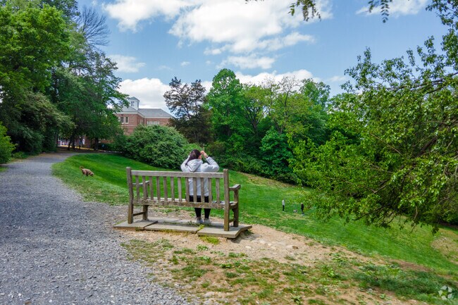 A woman sits with her dog at the Tregaron Conservancy on Macomb St NW in Cleveland Park.