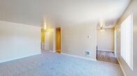 This single-floor, 3-bedroom, 1-bathroom home offers a thoughtfully arranged layout designed for comfortable everyday living. The living room serves as the central gathering space, featuring soft wall-to-wall carpet, neutral beige walls, and a front-facing window with vertical blinds that allows natural light to fill the room. A wall-mounted heater and ceiling fan contribute to year-round comfort.

The kitchen is equipped with wood-toned cabinetry, black appliances including a range and full-size refrigerator, a light wood-look vinyl floor, and a ceiling fan overhead — creating a practical and functional cooking space.

Each of the three bedrooms is finished with plush carpet and neutral walls. The primary bedroom offers a comfortable footprint, while the two secondary bedrooms each feature windows that bring in natural light and outdoor views. All bedrooms provide a clean, versatile canvas.

The bathroom includes a wide vanity with warm wood cabinetry, a laminate countertop, a large mirror, and wood-look flooring — offering a tidy and functional space. A dedicated laundry area houses a full-size top-load washer and dryer with overhead shelving for added storage.

Overall, the home presents a clean, functional, and well-maintained interior with consistent neutral tones throughout.
