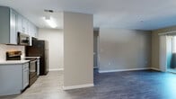 Located at 2021 N Milpitas Blvd in Milpitas, California, this single-floor residence offers a thoughtfully designed open-concept layout finished with consistent wood-look flooring throughout. The spacious living area is bathed in natural light through a sliding glass door that opens to a private balcony, providing a seamless indoor-outdoor connection with views of the surrounding greenery.

The galley-style kitchen is well-appointed with light gray shaker cabinetry, quartz-style countertops, a subway tile backsplash, and a full suite of stainless steel appliances including a refrigerator, electric range, over-the-range microwave, and dishwasher. A stainless steel sink with a modern brushed-gold faucet completes the functional workspace.

The bedrooms are generously sized, each featuring wood-look flooring and windows fitted with blinds that allow for controlled natural light. The hallway connects the living spaces to the private quarters with ease.

The bathrooms are finished with matching gray cabinetry and quartz-style countertops. One bathroom includes a full tub-shower combination, while another features a vanity with ample storage. Neutral warm-beige wall tones carry throughout the unit, contributing to a clean, cohesive, and modern aesthetic well-suited to everyday living.