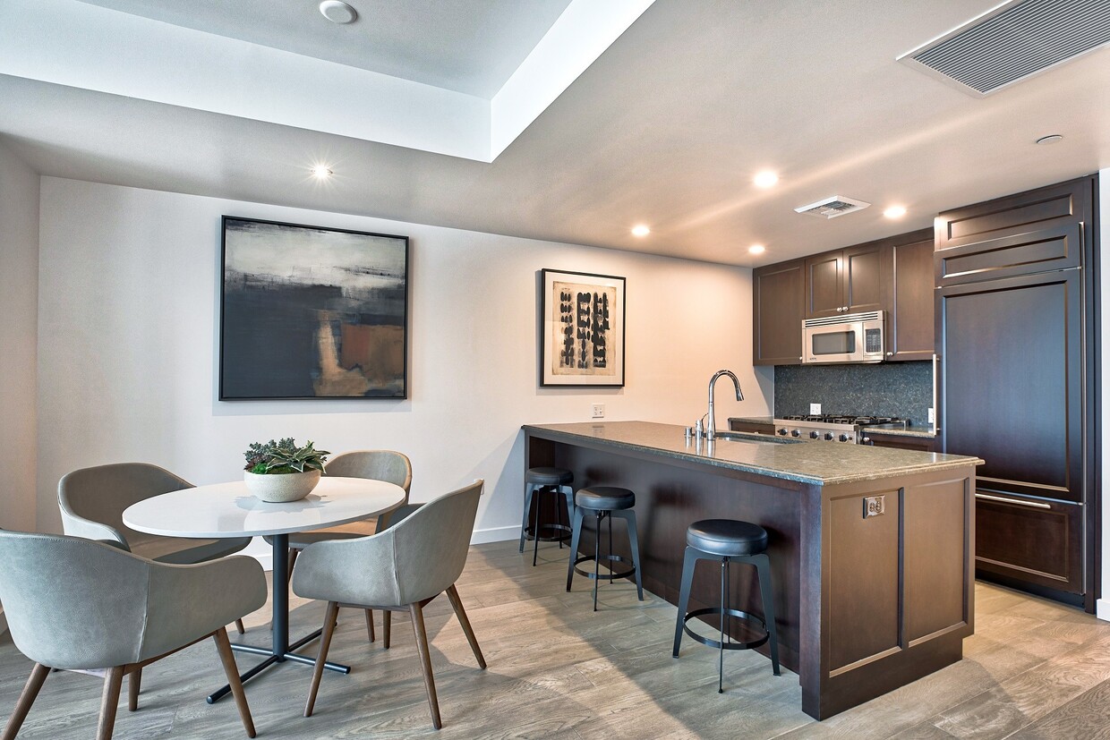 City Home kitchen featuring granite countertops and espresso cabinetry - The Bravern