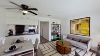 This single-floor residence offers a thoughtfully designed layout that maximizes comfort and functionality. The open-concept living and dining area serves as the heart of the home, featuring wood-look flooring, a textured ceiling, and a ceiling fan that enhances airflow and ambiance. A large window floods the living room with natural light and provides a pleasant outdoor view, while a neutral-toned sofa, round wooden coffee table, and a bold abstract wall art piece contribute to the space's modern aesthetic. An open metal shelving unit adds both style and storage.

The galley-style kitchen is efficiently organized with white upper cabinetry, a double stainless steel sink, and black appliances including a range and refrigerator. A subway tile backsplash adds a clean, contemporary touch, and wood-look flooring continues throughout for visual cohesion.

The bedroom is generously sized, offering wood-look flooring, a window with natural light, a textured ceiling, and ample room for furnishings. Its calm, neutral palette creates a restful retreat.

The bathroom features classic white subway tile lining the tub/shower surround, complemented by wood-look tile flooring, offering a crisp and clean finish throughout.