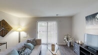 Located at Westbrooke Village in Manchester, Missouri, this single-floor residence offers a well-organized layout designed for comfortable everyday living. The living room serves as the heart of the home, showcasing rich hardwood-style flooring and a large sliding glass door flanked by vertical blinds that flood the space with natural light and provide views of the greenery outside. The open feel is further enhanced by a defining overhead beam that adds architectural character to the room.

Two bedrooms provide restful retreats, each finished with plush carpet flooring and natural light from windows dressed with curtains. Both rooms include sliding-door closets with built-in shelving and hanging rods, offering practical storage solutions. The full bathroom features hardwood-style flooring, a tub-shower combination, a toilet, and a vanity with dark cabinetry and a light countertop, keeping the space clean and functional.

The 3D dollhouse view reveals a thoughtfully connected floor plan, with a dining area positioned between the living room and the private bedroom wing. Neutral wall tones throughout create a cohesive, calm ambiance. The combination of natural light, durable flooring surfaces, and generous closet space makes this residence a practical and inviting home in the Westbrooke Village community.