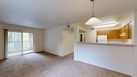 Located at 301 Avian Dr in Vallejo, California, this two-bedroom, one-bathroom residence offers a practical and comfortable single-floor layout. The open living room is generously sized, featuring warm neutral carpet, large windows with vertical blinds, and a sliding glass door that invites natural light and provides access to an outdoor area. A pendant-lit pass-through counter connects the living space to the kitchen, which is equipped with warm-toned wood cabinetry, a gas range, dishwasher, full-size refrigerator, and a double sink — all complemented by durable wood-look flooring. Both bedrooms are carpeted and feature windows with outdoor views of surrounding greenery, creating a calm and airy feel. The primary bedroom includes access to a dedicated closet with built-in shelving, offering practical storage. The full bathroom is clean and functional, featuring a combined tub and shower with a white surround and wood-look flooring. Throughout the unit, a consistent neutral color palette and natural light contribute to a bright, cohesive atmosphere. This well-organized layout makes efficient use of its space, providing all essential areas within a single floor.