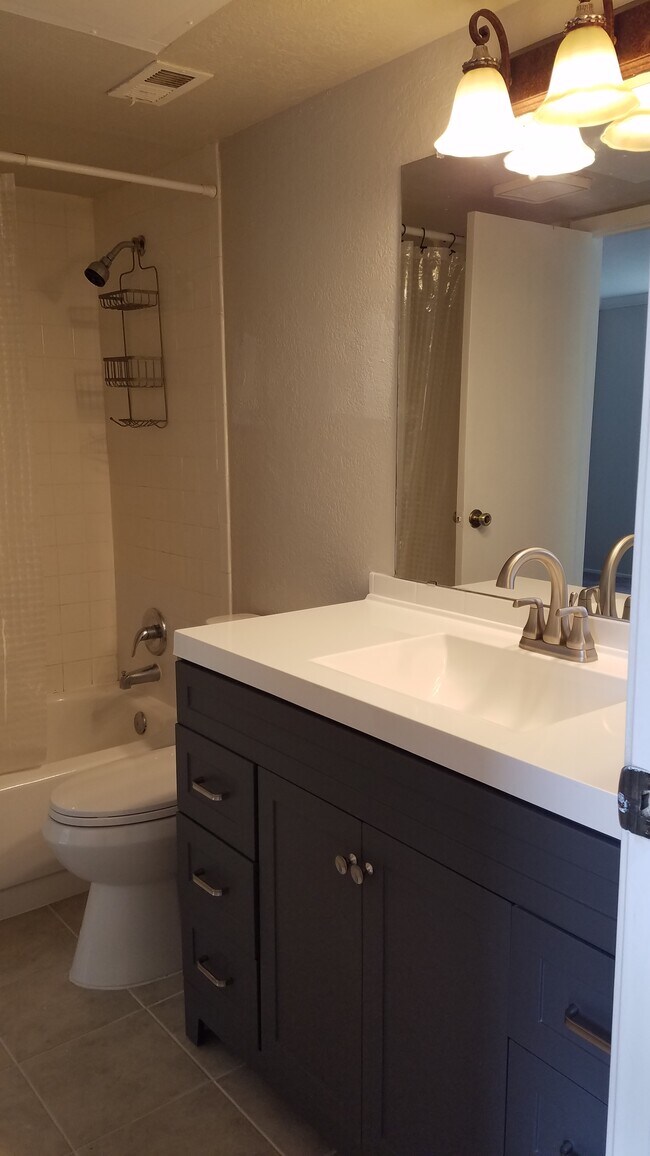 Baño renovado con nuevo tocador alto y pisos de baldosas. - 14777 Wunderlich Dr