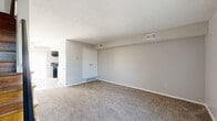 Located at 181 Derrer Rd in Columbus, Ohio, this two-story home offers a practical and well-organized layout spread across two floors. The main level features a spacious carpeted living room with a textured ceiling, built-in closet, and multiple vents for efficient climate control, adjacent to a galley-style kitchen equipped with dark wood cabinetry, a gas range, refrigerator, overhead ventilation hood, and a double sink set against light countertops and tile flooring. The upper floor hosts both bedrooms, each featuring warm hardwood flooring, neutral gray walls, and natural light from windows. The primary bedroom offers generous proportions and a dedicated closet, while the second bedroom also includes closet access and connects to the hallway staircase. A full bathroom on the upper level includes a single-sink vanity with wood cabinetry, a white countertop, a wall mirror, and a shower-tub combination. Throughout the home, six-panel white doors, clean white trim, and a consistent neutral color palette contribute to a bright, cohesive aesthetic. The staircase, finished in hardwood, connects both levels and adds warmth to the overall interior character of this straightforward and functional Columbus residence.