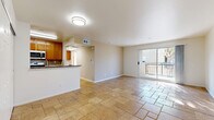 Located at 9601 Reseda Blvd in the Northridge neighborhood of Los Angeles, this one-bedroom, one-bathroom residence offers a well-organized, single-level layout with a cohesive and functional design throughout. The living area is open and airy, finished with warm travertine stone tile flooring that extends seamlessly across the entire unit, lending a sense of continuity and understated elegance. Large sliding glass doors flood the main living space with natural light and open onto a private balcony, offering a pleasant outdoor retreat with views of surrounding greenery. The kitchen features warm wood cabinetry, a dark granite countertop, and a tile backsplash, with a pass-through counter connecting it conveniently to the living area. The spacious bedroom is bright and inviting, benefiting from a large window that draws in natural light, and includes a closet with paneled double doors for generous storage. The bathroom is neatly appointed with matching wood vanity cabinetry, a granite countertop, a combined tub and shower enclosed by sliding glass doors, and built-in shelving for added storage. Clean white walls and neutral tones throughout the unit create a calm, versatile ambiance well-suited to a variety of living styles.