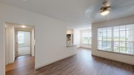 This single-story unit in Houston, TX (77396) offers a thoughtfully designed layout with a clean, modern aesthetic throughout. The open-concept living and dining area is anchored by durable wood-look flooring and a ceiling fan with integrated lighting. Large windows along the exterior wall invite generous natural light and outdoor views, creating a bright and welcoming atmosphere.

A pass-through counter connects the living space to the kitchen, which features granite-look countertops, gray shaker-style cabinetry, and stainless steel appliances including a refrigerator, range, and dishwasher. The wood-look flooring continues through the kitchen, maintaining a cohesive design.

The bedrooms are carpeted for comfort and each include ceiling fans and windows that provide natural light. At least one bedroom offers a walk-in closet with built-in shelving. Additional bedrooms feature standard closets with adequate storage.

The bathroom is finished with wood-look flooring, a granite-top vanity with gray cabinetry, and a soaking tub with a tiled surround and brushed nickel fixtures. The overall palette of white walls, neutral tones, and brushed nickel hardware gives the unit a consistent, contemporary feel throughout.