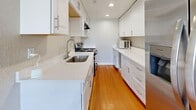 Located on E First Ave in Salt Lake City's desirable Capitol Hill area, this single-floor, 2-bedroom, 1-bathroom home offers a thoughtfully arranged layout that maximizes its compact footprint. The living room serves as the heart of the home, featuring warm hardwood floors, crown molding, and a ceiling fan, with multiple windows allowing natural light to fill the space. The galley-style kitchen has been updated with crisp white cabinetry, quartz countertops, a stainless steel sink, and matching appliances, all set atop classic hardwood flooring with recessed lighting overhead. Both bedrooms are carpeted and finished in neutral tones, each offering a window with blinds for natural light and privacy, along with built-in closets with paneled sliding or hinged doors. The connecting hallway provides a smooth transition between the living areas and the bedrooms. The bathroom features hardwood flooring, a pedestal sink, a medicine cabinet with mirror, and tiled wainscoting, lending a clean and classic look. White trim and baseboards throughout the home create a cohesive, well-maintained aesthetic, while the overall neutral palette makes the space versatile and move-in ready.