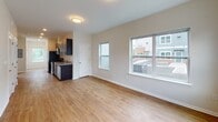 Located at 4909 Hamilton Ave in Baltimore, MD, this single-floor unit offers a clean, modern aesthetic throughout. The open-concept living and dining area is bathed in natural light from large double-pane windows that frame views of the surrounding neighborhood. Warm-toned hardwood-style flooring flows seamlessly across the main living spaces, complementing the neutral wall tones and crisp white trim.

The kitchen is well-appointed with rich dark cabinetry, granite countertops, and a full suite of stainless steel appliances including a refrigerator, electric range, built-in microwave, and dishwasher — offering both style and functionality.

The bedrooms are generously sized, each featuring hardwood-style flooring, bright windows with neighborhood views, and ample closet access. The primary bedroom includes a dedicated en-suite bathroom, while a second full bathroom serves the remaining rooms. Both bathrooms are finished with large-format tile flooring, dark wood vanities with white countertops, and clean, bright fixtures. One bathroom features a full soaking tub and shower combination.

The unit's layout is practical and well-organized, with a clear separation between living and sleeping areas. The overall ambiance is bright, clean, and move-in ready, reflecting a contemporary residential design.