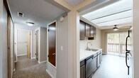 Located at 29843 Clearbrook Cir in Hayward, CA, this one-bedroom, two-bathroom unit offers a practical and comfortable single-floor layout. The living room is generously proportioned, featuring plush wall-to-wall carpeting, neutral taupe walls, a textured ceiling, and large sliding glass doors flanked by vertical blinds that fill the space with natural light and provide access to an outdoor patio. A fireplace adds a functional focal point to the living area.

The galley-style kitchen is efficiently designed with rich dark wood cabinetry, light countertops, black appliances including a refrigerator, range, and dishwasher, and a stainless steel sink. Vinyl plank-style flooring runs throughout the kitchen, offering easy maintenance.

The primary bedroom is well-sized, featuring soft carpet, a window with vertical blinds for natural light, and a closet with wood-toned doors. Both bathrooms are finished with matching dark vanity cabinetry, light countertops, and vinyl flooring. The main bathroom includes a dual-sink vanity and a separate water closet for added privacy.

A hallway with a dedicated closet completes the layout, providing additional storage. The unit's neutral color palette and consistent finishes create a cohesive and functional living environment throughout.