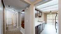 Located at 29843 Clearbrook Cir in Hayward, CA, this one-bedroom, two-bathroom unit offers a practical and comfortable single-floor layout. The living room is generously proportioned, featuring plush wall-to-wall carpeting, neutral taupe walls, a textured ceiling, and large sliding glass doors flanked by vertical blinds that fill the space with natural light and provide access to an outdoor patio. A fireplace adds a functional focal point to the living area.

The galley-style kitchen is efficiently designed with rich dark wood cabinetry, light countertops, black appliances including a refrigerator, range, and dishwasher, and a stainless steel sink. Vinyl plank-style flooring runs throughout the kitchen, offering easy maintenance.

The primary bedroom is well-sized, featuring soft carpet, a window with vertical blinds for natural light, and a closet with wood-toned doors. Both bathrooms are finished with matching dark vanity cabinetry, light countertops, and vinyl flooring. The main bathroom includes a dual-sink vanity and a separate water closet for added privacy.

A hallway with a dedicated closet completes the layout, providing additional storage. The unit's neutral color palette and consistent finishes create a cohesive and functional living environment throughout.