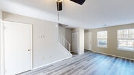 Located at 1026 North Blvd in Bethlehem, PA, this two-bedroom, one-bathroom home spans three floors, offering a well-organized and functional layout. The main living level features light-toned hardwood-style flooring throughout, neutral beige walls, and a staircase with white railings that adds a classic touch to the open living area. A ceiling fan overhead and natural light from street-facing windows create a bright, comfortable atmosphere. The kitchen is equipped with rich wood cabinetry, marble-look countertops, a gas range, microwave, and refrigerator, all finished in white. A sliding glass door leads directly to a fenced rear outdoor area, providing convenient backyard access. Both bedrooms are carpeted and bathed in natural light from well-positioned windows. The primary bedroom features a spacious built-in closet with louvered doors, while the second bedroom offers a clean, versatile space. The full bathroom includes a tub-shower combo with clean white surrounds, a toilet, and a vanity. The unfinished basement provides additional utility and storage space, accessible via its own staircase. A dedicated utility room rounds out the lower level, adding practical functionality to this well-structured Bethlehem home.