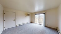 Located at 1367 Concord Place Dr in Kalamazoo, Michigan, this single-floor unit offers a practical and straightforward layout designed for comfortable everyday living. The living area is finished with plush carpet and features a wall-mounted air conditioning unit, a baseboard heating system, and a sliding glass door that opens onto a private balcony with views of the surrounding community. The space is bright and open, providing a welcoming atmosphere. The galley-style kitchen is efficiently arranged with cream-toned cabinetry, ample upper and lower storage, a double-basin sink, a gas range, and a full-size refrigerator, all set atop durable tile flooring. The bedrooms are carpeted and neutrally finished, with one room featuring a built-in closet equipped with shelving and a hanging rod for organized storage, and another room that includes a small access panel on the wall. The full bathroom is clean and functional, offering a tub and shower combination, a toilet, and a vanity with a countertop sink, all finished with tile flooring. Baseboard heating runs throughout the carpeted areas, ensuring consistent warmth. The overall aesthetic is clean, neutral, and move-in ready, making this unit a practical option in the Kalamazoo area.