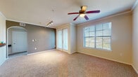 This single-floor residence offers a thoughtfully designed open-concept layout that seamlessly connects the living, dining, and kitchen areas. The living room is a standout space, featuring crown molding, a ceiling fan, and large windows that invite natural light, while French doors provide direct access to the outdoors. A second sitting or flex area with track lighting and a contrasting accent wall adds versatility to the floor plan. Elegant arched doorways frame transitions between spaces, lending architectural charm throughout.

The kitchen is well-equipped with rich cherry-toned cabinetry, dark granite-style countertops, black appliances including a refrigerator, range, and microwave, and a peninsula with a built-in sink ideal for casual dining or food preparation. A globe chandelier overhead adds a stylish focal point.

The bedrooms are comfortable and well-proportioned, each featuring plush carpeting, ceiling fans, and generous windows with outdoor views. The bathroom is finished with matching cherry cabinetry, a wide vanity with granite-style countertops, a large mirror, and wood-look flooring that ties cohesively to the kitchen and entryway. Throughout the home, a warm, neutral color palette and consistent finishes create a cohesive and inviting ambiance.