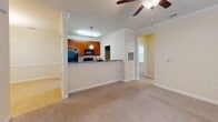 Located at 41 Brittany Place Dr. in Hendersonville, NC, this single-floor residence offers a well-designed, functional layout with consistent finishes throughout. The kitchen is a standout space, featuring rich cherry wood cabinetry, granite countertops, tile flooring, and black appliances including an electric range and over-the-range microwave. A peninsula counter opens the kitchen toward the main living area, which is finished with plush carpet, crown molding, and a ceiling fan — creating a comfortable, cohesive space. Natural light filters through multiple windows fitted with blinds across the living and bedroom areas. The bedrooms are generously proportioned, each with soft carpet flooring, neutral warm-toned walls, and individual overhead lighting. The bathrooms mirror the kitchen's aesthetic with granite-topped cherry vanities and tile flooring; one bathroom includes a soaking tub and shower combination, while the other features a walk-in shower configuration. A utility area with louvered doors provides convenient access to the electrical panel and additional storage. Throughout the home, clean white baseboards and a consistent warm neutral color palette lend a cohesive, move-in-ready feel to this Hendersonville property.