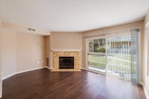 Located at 2530 Bear Valley Pkwy in Escondido, CA, this single-story, 3-bedroom, 2-bathroom home offers a well-designed layout that balances comfort and functionality. The living room is a welcoming focal point, featuring rich wood-style flooring, neutral warm-toned walls, and a tile-surround fireplace with a classic white mantel. Sliding glass doors flood the space with natural light and open directly to a private patio with outdoor views. The kitchen is well-appointed with light wood cabinetry, dark granite countertops, tile flooring, and a full suite of stainless steel appliances including a refrigerator, range, microwave, and dishwasher. It flows seamlessly into the adjacent dining area. The three bedrooms continue the wood-style flooring and offer generous closet space, including a spacious walk-in closet with multi-level shelving and hanging rods. The bathrooms feature tile flooring, warm wood vanities, dark granite countertops, and tiled tub/shower surrounds. A dedicated laundry room with side-by-side washer and dryer hookups adds everyday convenience. The home's cohesive design, practical storage, and bright, airy feel make it a comfortable residence in Southern California.