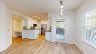 Located at 5040 Camino San Fermin in San Diego, CA, this single-story, 3-bedroom, 2-bathroom home offers a well-designed layout with a bright, open feel throughout. Light wood-look flooring runs through the main living areas, complementing the neutral white walls and abundant natural light streaming in through multiple windows with views of surrounding greenery.

The open-concept kitchen is a standout feature, showcasing white shaker cabinetry, a mosaic tile backsplash, quartz countertops, and a full suite of stainless steel appliances including a gas range, over-range microwave, refrigerator, and a built-in wine cooler. A central island provides additional prep space and flows naturally into the combined dining and living area.

The three bedrooms are carpeted and well-proportioned, with the generously sized primary bedroom offering a large walk-in closet equipped with wire shelving systems. The two bathrooms are finished with large-format light tile flooring, modern vanities, and clean, minimal fixtures.

A dedicated laundry room with full-size washer and dryer hookups adds everyday convenience, while the attached garage provides substantial additional space for parking and storage. The home's single-floor layout ensures seamless flow between all rooms, making it a functional and comfortable residence in a desirable San Diego location.