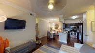 This single-story residence offers two bedrooms and two bathrooms within a thoughtfully designed open-concept floor plan. The living area is bright and welcoming, featuring rich dark hardwood floors, crown molding, and a ceiling fan. A large sliding glass door floods the space with natural light and provides views of the outdoors, creating a seamless connection between interior and exterior.

The kitchen is well-equipped for everyday living, showcasing dark espresso cabinetry, light granite countertops, a subway tile backsplash, and stainless steel appliances including a range, microwave, and dishwasher. A peninsula with a sink overlooks the adjacent dining area, enhancing the open flow between spaces.

Both bedrooms offer a comfortable retreat, each featuring carpet flooring, ceiling fans, and windows that invite natural light. The primary bathroom features a double-sink vanity with dark cabinetry, light countertops, and framed mirrors. The second bathroom provides a clean, functional design with a shower-tub combination and single vanity. Throughout the residence, a neutral color palette and consistent finishes create a cohesive and inviting atmosphere.