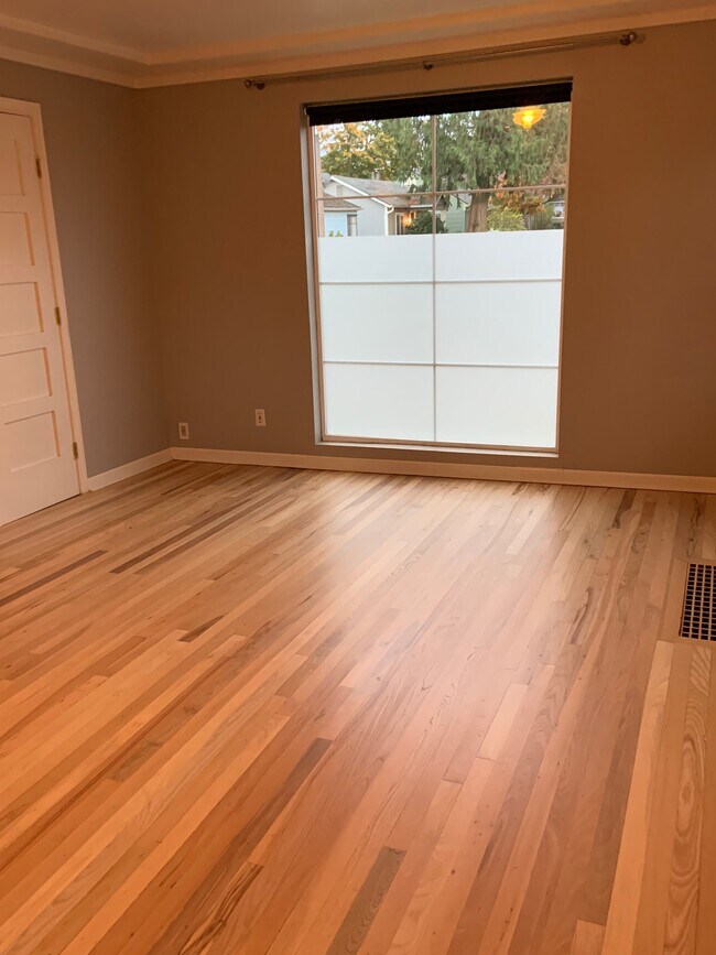 Amplia sala de estar con pisos de madera restaurados recientemente. - 1601 NE Holman St