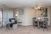 This single-floor residence at 26598 E Carnegie Park Dr in Southfield, Michigan, offers a thoughtfully arranged layout designed for comfortable everyday living. The living area is generously sized, featuring warm neutral carpet, a textured ceiling, and an abundance of natural light provided by large windows and a sliding glass door that opens to an outdoor space. The open-concept design connects the living room seamlessly to the dining area, which is defined by a half-wall partition that also serves as a pass-through to the kitchen, enhancing the sense of openness throughout.

The galley-style kitchen is efficiently laid out with ample white cabinetry featuring wood-trimmed accents, light countertops, a stainless sink, and white appliances including a refrigerator and dishwasher. Hardwood-style flooring runs through the kitchen, adding warmth and contrast to the carpeted living spaces.

The bedrooms are comfortably sized, each featuring plush carpet, neutral-toned walls, and windows that bring in natural light and outdoor views. The primary bedroom includes a walk-in closet for added storage. The full bathroom offers a vanity with a large mirror, wood-accented cabinetry, and a shower/tub combination. A dedicated space with a stacked in-unit washer and dryer adds practical convenience to this well-appointed home.
