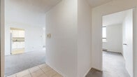 Located at 1551 Riverside Dr in Ottawa, this two-bedroom, one-bathroom unit offers a practical and well-organized single-floor layout. The interior is bright and clean throughout, with white walls and neutral tones creating a light, airy atmosphere.

The living area is generously proportioned, featuring soft carpet flooring and an open sightline toward the kitchen. The kitchen is efficiently designed with white cabinetry — both upper and lower — granite-look laminate countertops, a stainless steel sink, and tile flooring, providing ample storage and workspace.

Both bedrooms are carpeted and finished with clean white walls. The primary bedroom is a comfortable size and features a full-width sliding wood-panel closet, offering substantial storage. The second bedroom also includes a matching sliding wood-panel closet and benefits from a large window that brings in natural light and outdoor views of the surrounding greenery. A baseboard heating unit is present in both bedrooms.

The bathroom includes a tiled tub-shower surround, tile flooring, a toilet, and a vanity with countertop, maintaining a clean and functional aesthetic throughout.

A hallway connects the rooms efficiently, contributing to the unit's well-structured and easy-to-navigate floor plan.