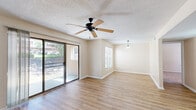 This well-appointed 2-bedroom, 2-bathroom single-floor home in El Paso, TX offers a practical and comfortable layout designed for everyday living. The living room is a bright, open space anchored by wood-look hardwood flooring, a ceiling fan, and a large sliding glass door that fills the room with natural light and provides direct access to an outdoor patio with views of the surrounding greenery. The adjacent dining area features a pendant light fixture, continuing the open feel of the main living space.

The galley-style kitchen is efficiently arranged with warm wood cabinetry, granite-look countertops, black appliances, and a skylight-style ceiling panel that brightens the workspace. A pantry with built-in shelving adds convenient storage just off the kitchen.

Both bedrooms offer plush carpeting and natural light through windows with blinds. The spacious primary bedroom includes access to a walk-in closet outfitted with dual hanging rods and shelving on both sides. The home includes four closets in total, providing ample storage throughout.

The two bathrooms are clean and functional. One features a tub-shower combo with white tile surround, while the other includes a wood-toned vanity with granite countertop and wood-look tile flooring. Textured ceilings are present throughout, adding a classic finishing touch to this move-in-ready home.