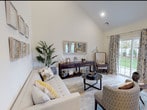 Located at 588 Bicycle Path in Port Jefferson Station, New York, this two-story home offers a refined blend of modern design and comfortable living. The main living area immediately impresses with soaring vaulted ceilings that lend an open, airy feel to the space. Large sliding glass doors flood the room with natural light while providing direct views of the outdoor greenery, creating a seamless connection between interior and exterior. The living room features light hardwood flooring that flows throughout the main level.

The kitchen is outfitted with crisp white shaker-style cabinetry, light quartz countertops, stainless steel appliances, and a tasteful mosaic tile backsplash, combining style with functionality. A convenient half bathroom on the main floor features elegant pedestal sink and a decorative gold-framed mirror.

The bedrooms are generously proportioned, with the primary bedroom benefiting from multiple large windows that bathe the room in natural light and offer pleasant outdoor views. Closet space and light hardwood flooring complete the bedroom. Additional full bathrooms are finished with clean white vanities and large-format tile flooring. The home also includes an attached garage, providing practical storage and parking. Every detail reflects a commitment to quality and modern comfort throughout.