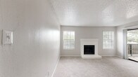 Located in Dallas, TX, this single-floor, 2-bedroom, 2-bathroom residence offers a practical and well-appointed layout. The open living room greets you at the entry with soft carpet flooring, neutral gray walls, and a textured ceiling, with sliding glass doors that invite natural light and provide access to an outdoor balcony. The adjacent kitchen is efficiently designed with wood-look flooring, white cabinetry with modern hardware, granite-style countertops, a classic subway tile backsplash, and stainless steel appliances including a refrigerator, electric range, microwave, and dishwasher. Both bedrooms are carpeted and feature ceiling fans with lighting, windows with blinds for natural light, and dedicated closets. The spacious primary bedroom includes a walk-in closet with built-in shelving. The second bedroom also offers closet access. Each bathroom is clean and functional, featuring a tub-shower combination, tile surround, wood-look flooring, and granite-style vanity countertops. The overall aesthetic is consistent throughout—neutral tones, updated finishes, and practical design elements that create a comfortable and move-in-ready living environment.