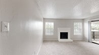 Located in Dallas, TX, this single-floor, 2-bedroom, 2-bathroom residence offers a practical and well-appointed layout. The open living room greets you at the entry with soft carpet flooring, neutral gray walls, and a textured ceiling, with sliding glass doors that invite natural light and provide access to an outdoor balcony. The adjacent kitchen is efficiently designed with wood-look flooring, white cabinetry with modern hardware, granite-style countertops, a classic subway tile backsplash, and stainless steel appliances including a refrigerator, electric range, microwave, and dishwasher. Both bedrooms are carpeted and feature ceiling fans with lighting, windows with blinds for natural light, and dedicated closets. The spacious primary bedroom includes a walk-in closet with built-in shelving. The second bedroom also offers closet access. Each bathroom is clean and functional, featuring a tub-shower combination, tile surround, wood-look flooring, and granite-style vanity countertops. The overall aesthetic is consistent throughout—neutral tones, updated finishes, and practical design elements that create a comfortable and move-in-ready living environment.