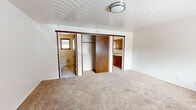Located at 2217 Maple Valley Hwy in Renton, WA, this single-floor unit offers an efficiently designed layout that maximizes its compact footprint. The living area features neutral carpet flooring, light-toned walls, and a large window that allows generous natural light to fill the space, creating an open and airy feel. A wall-mounted heater and flush-mount ceiling light are standard throughout.

The generously sized bedroom is the largest room in the unit, featuring soft carpet flooring, sliding wood-panel closet doors providing ample storage, and direct visual access to the kitchen. The open sightlines between the bedroom and kitchen contribute to an interconnected, functional layout.

The kitchen is equipped with warm wood cabinetry, a white electric coil range, a double-basin stainless steel sink, and light tile flooring. A window above the counter brings in natural light, and a wall heater ensures year-round comfort. Counter space is available along one wall for food preparation.

The full bathroom includes a single-sink vanity with wood cabinetry, a tiled tub-and-shower combination, tile flooring, a wall heater, and a window for ventilation and natural light. The unit also includes a dedicated laundry area, adding everyday convenience.
