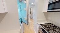 This well-appointed 1-bedroom, 1-bathroom residence offers a thoughtfully designed single-floor layout with a clean, modern aesthetic throughout. Light hardwood floors extend seamlessly across every room, complementing the bright white walls and recessed lighting that create a fresh, open atmosphere.

The kitchen is efficiently designed and outfitted with high-quality stainless steel Bosch appliances, including a gas range, over-the-range microwave, and a full-size refrigerator. White cabinetry reaches toward the ceiling, providing generous storage, while light quartz countertops complete the contemporary look.

The living area offers a generous, open layout with large black-framed windows that invite natural light and provide outdoor views, adding to the airy feel of the space. Baseboard heating runs along the perimeter, ensuring year-round comfort.

The bedroom is a comfortable, well-proportioned retreat featuring a dedicated closet with ample storage space, recessed lighting, and the same warm hardwood flooring found throughout the residence.

The full bathroom is finished with large-format taupe tiles on both the walls and floor, lending a spa-like ambiance. It features a soaking tub with a handheld shower, a wall-mounted white vanity, a mirrored medicine cabinet, and a toilet, all arranged in a clean and functional layout.