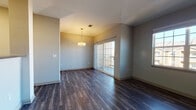 Located at 4255 Kittredge St in Denver, Colorado, this single-floor unit offers a well-designed layout with a variety of functional living spaces. The open living and dining area is anchored by rich, dark hardwood-style flooring that runs throughout the main areas, complemented by neutral gray walls and ample natural light streaming in through large windows and sliding glass doors that lead to an outdoor balcony. A pendant light fixture adds a warm focal point to the dining space.

The kitchen is thoughtfully appointed with crisp white cabinetry, dark countertops, a stainless steel undermount sink with a modern pull-down faucet, and a full suite of stainless steel appliances including a range, microwave, and dishwasher. White subway tile backsplash adds a clean, contemporary touch, while the hardwood-style flooring continues seamlessly throughout.

The bedrooms feature plush wall-to-wall carpeting and generous natural light from well-placed windows. One bedroom includes direct access to a dedicated closet as well as an adjoining bathroom, offering added convenience. The bathroom is finished with classic white tile surrounding a full soaking tub and shower combination, accented by a subtle decorative tile border. The space presents a clean, move-in ready aesthetic throughout.