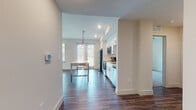 This single-floor residence offers a thoughtfully designed layout with a clean, contemporary aesthetic throughout. The open-concept kitchen and dining area serves as the heart of the space, featuring white shaker-style cabinetry extending to the ceiling, stainless steel appliances including a French door refrigerator, electric range, and built-in microwave. A subway tile backsplash and pendant lighting above the dining area add modern character, while durable wood-look flooring flows throughout the common areas.

The adjoining living and dining space is bright and open, benefiting from multiple windows that invite natural light. Ceiling fans are present in the living area and bedrooms, enhancing comfort throughout.

The bedrooms are carpeted for warmth and comfort, each featuring windows with blinds and ceiling fans. One bedroom includes a reach-in closet with wire shelving, while the primary bedroom is complemented by a generous walk-in closet outfitted with multi-tier wire shelving on three walls and wood-look flooring.

Two well-appointed bathrooms serve the unit. One features a soaking tub with a marble-style tiled surround and brushed nickel fixtures. The other offers a walk-in shower with matching marble-look tile, a frameless glass enclosure, a double-sink vanity with white cabinetry, and a large mirror—both finished with wood-look flooring for a cohesive, polished look.