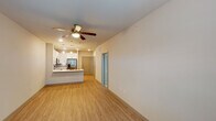 This 1-bedroom, 1-bathroom unit in Houston, TX (77084) offers a thoughtfully designed, single-floor layout that maximizes both comfort and functionality. The open-concept living and kitchen area is anchored by warm wood-style flooring and a ceiling fan with integrated lighting, creating a bright and cohesive space. The modern kitchen is a standout feature, showcasing white shaker-style cabinetry, a mosaic tile backsplash, stainless steel appliances including a refrigerator with ice maker, electric range, over-the-range microwave, and dishwasher. A peninsula with pendant lighting and an undermount sink provides additional prep space and casual seating. The bedroom is a comfortable retreat with plush carpeting, a ceiling fan, and two windows fitted with blinds that allow for natural light and privacy. The full bathroom features a white vanity with ample cabinet storage, a framed mirror, and wood-style flooring, with direct access to a dedicated walk-in closet complete with built-in shelving and hanging rods. The unit also includes a security system panel and recessed entryway. The neutral color palette and clean finishes throughout create a modern and move-in-ready atmosphere.