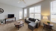 Located at 20 Brickyard Dr in Bloomington, Illinois, this single-floor unit offers a well-organized layout designed for comfortable everyday living. The living room is a welcoming centerpiece, featuring large windows that flood the space with natural light, soft carpeted flooring, a ceiling fan, and direct access to an exterior door — creating an open, airy atmosphere. Neutral gray walls and a textured ceiling complement the versatile, functional feel of the room.

The kitchen is efficiently laid out in an L-shaped configuration, equipped with white cabinetry featuring light wood trim, ample counter space, and white appliances including a refrigerator and an electric range. Light tile flooring carries through the kitchen and into an adjacent utility area, which houses in-unit washer and dryer hookups along with an electrical panel — a practical and convenient feature.

The bedroom is a comfortable retreat with plush carpeting, a large window with draping for privacy, and a dedicated walk-in closet offering generous storage. The bathroom is clean and straightforward, featuring a single-sink vanity, a toilet, and a full shower-tub combination with a curtain rod. Soft tile flooring and neutral-toned walls complete the space. Overall, the unit presents a functional and well-maintained interior in a convenient Bloomington location.