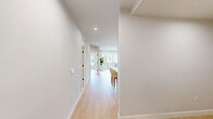 Located at 122 Elm St in Westfield, NJ, this thoughtfully designed 3-bedroom, 2-bathroom residence offers a clean, modern aesthetic across a single, well-organized floor. Light hardwood flooring flows seamlessly throughout, complementing the bright, neutral palette that defines every room.

The kitchen is a standout, featuring white shaker cabinetry with brushed gold hardware, a subway tile backsplash, quartz countertops, stainless steel appliances including a gas range and French door refrigerator, and a center island with seating — all illuminated by elegant pendant lighting. The open layout connects naturally to the living area, which opens to a private balcony through large sliding glass doors, offering outdoor views and generous natural light.

The spacious primary bedroom includes access to a well-appointed en suite bathroom finished with marble-style tile flooring and walls, a soaking tub, and a wood-toned vanity. A dedicated walk-in closet with built-in shelving adjoins the suite. The second bathroom mirrors the same refined marble finishes, complete with a tub-shower combination.

The two additional bedrooms are bright and versatile, each with large windows and hardwood floors. A separate laundry room with built-in shelving and a full-size washer adds everyday convenience. The hallway connects all spaces efficiently, rounding out this polished and functional home.