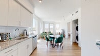 This thoughtfully designed one-bedroom, one-bathroom unit at 18900 Parthenia St in Los Angeles offers a clean, modern aesthetic throughout. Light wood flooring flows seamlessly across the entire floor plan, complementing the crisp white walls and creating a bright, cohesive feel.

The open-concept living and dining area is a standout feature, bathed in natural light from multiple large windows that frame outdoor views of the surrounding neighborhood. The living space offers generous room for comfortable seating arrangements, while the adjacent dining area provides an ideal setting for meals.

The kitchen is efficiently laid out with light gray cabinetry, granite-style countertops, a subway tile backsplash, and a full suite of stainless steel appliances including a range, dishwasher, microwave, and refrigerator.

The bedroom is well-proportioned, featuring a window with outdoor views, and direct access to a dedicated walk-in closet complete with built-in hanging rods and shelving. In-unit laundry is also accessible from the bedroom area.

The bathroom is finished with a granite-topped vanity, an illuminated mirror, and a tiled tub-shower combination. Throughout the unit, the design prioritizes clean lines, functionality, and a light, airy ambiance.