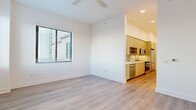 Located at 468 Quay Commons in the heart of downtown Sarasota, FL, this efficiently designed one-bedroom, one-bathroom residence offers a clean, modern aesthetic throughout its thoughtfully arranged single-floor layout. Light wood-tone flooring runs continuously through the living areas and bedroom, complementing the bright white walls and recessed lighting that keep the space feeling open and airy.

The galley-style kitchen is well-appointed with light wood cabinetry, white quartz countertops, a textured tile backsplash, and a full suite of stainless steel Whirlpool appliances, including a bottom-freezer refrigerator, electric range, and over-the-range microwave. A stainless steel sink with a flexible coil-neck faucet adds a functional, contemporary touch. The kitchen flows naturally into the main living area, which is bathed in natural light from a large window fitted with horizontal blinds and is finished with a ceiling fan overhead.

The bedroom is an intimate, serene space featuring dual corner windows that frame elevated views of the Sarasota skyline, filling the room with natural light and providing an urban backdrop. The bathroom offers a clean, spa-like feel with floor-to-ceiling vertical tile surrounding a soaking tub and shower combination, chrome fixtures, and a built-in niche for storage. This residence presents a polished, move-in-ready option in a prime downtown Sarasota location.
