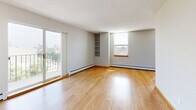 Located at 700 Douglas Ave in Minneapolis, MN, this 2-bedroom, 2-bathroom residence offers a well-organized single-floor layout designed for comfortable everyday living. The open living and dining area is bathed in natural light from multiple windows and a sliding glass door that leads to a private balcony with city views. Light hardwood flooring runs throughout the main living spaces, complemented by neutral gray walls and a textured ceiling. Built-in shelving adds functional character to the living area. The galley-style kitchen is a standout feature, showcasing rich dark wood cabinetry, marble-look countertops, a subway tile backsplash, stainless steel appliances, and hardwood flooring — providing both style and efficiency. Both bedrooms are carpeted and offer natural light via well-placed windows, ceiling fans, and built-in shelving niches. The generously sized primary bedroom includes a mirrored sliding closet door alongside an open closet with built-in organizers. The two bathrooms feature white tile flooring, dark vanity cabinetry, and clean white fixtures. Additional highlights include five closets, an in-unit laundry area, and a hallway with large floor-to-ceiling storage. The space offers a practical, move-in-ready layout in a prime Minneapolis location.