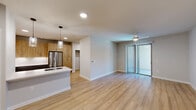 Located in Austin's vibrant 78702 zip code, this well-appointed 2-bedroom, 3-bathroom residence offers a thoughtfully designed single-level layout with modern finishes throughout. The open-concept living and kitchen area serves as the heart of the home, featuring warm light wood-tone flooring, recessed and pendant lighting, and a ceiling fan. A sliding glass door floods the space with natural light and provides access to an outdoor area. The kitchen is outfitted with stainless steel appliances — including a range, microwave, and refrigerator — complemented by two-tone cabinetry pairing wood-finished uppers with grey lower cabinets, white quartz countertops, and a hexagonal tile backsplash. The primary bedroom is generously sized, offering its own sliding door access to the outdoors, a ceiling fan, and direct entry to a private en-suite bathroom featuring a glass-enclosed walk-in shower with subway tile, large-format floor tile, and access to a well-organized walk-in closet with built-in shelving and double hanging rods. The second bedroom includes a ceiling fan, built-in closet, and an adjacent bathroom. A third bathroom features a soaking tub with full subway tile surround and wood-tone vanity cabinetry, consistent with the home's cohesive design aesthetic.
