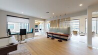 Located at 44 Veterans Memorial Dr in Somerville, NJ, this single-floor amenity space is designed with a contemporary aesthetic that seamlessly blends comfort and sophistication. Light-toned hardwood-style flooring flows throughout, unifying the various distinct zones within the space.

The main lounge area features exposed natural wood ceiling beams, elegant globe pendant lighting, and floor-to-ceiling windows that flood the interior with natural light and frame views of the surrounding residential courtyard. Plush seating arrangements, including sofas and accent chairs, create inviting areas for relaxation and socializing.

A stylish clubroom area showcases a vertically tiled double-sided fireplace as its centerpiece, flanked by multiple seating groupings. The game room includes a full-size billiards table, accent lighting, and comfortable lounge seating with access to an outdoor area.

A sophisticated lounge nook features upholstered booth-style seating with a decorative slatted wood partition, complemented by teal bar-height chairs and pendant lighting. A dedicated dining area with a round table and modern chairs adds further functionality.

Throughout the space, large-format windows provide abundant natural light and outdoor connectivity, while curated artwork, layered rugs, and carefully selected furnishings contribute to a polished, modern atmosphere.